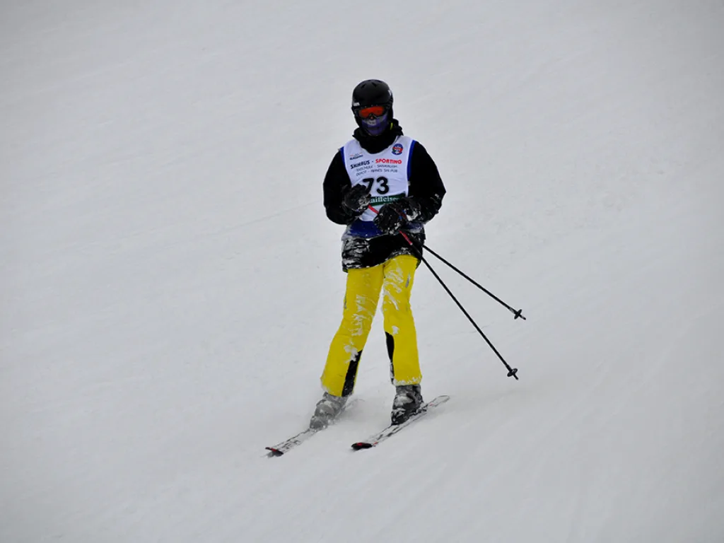 Skifahrer mit Startnummer 73 in gelber Hose.